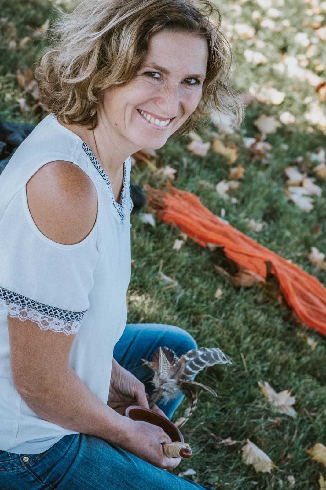 Claudia Reisecker mit einer Feder, herzlich lächelnd