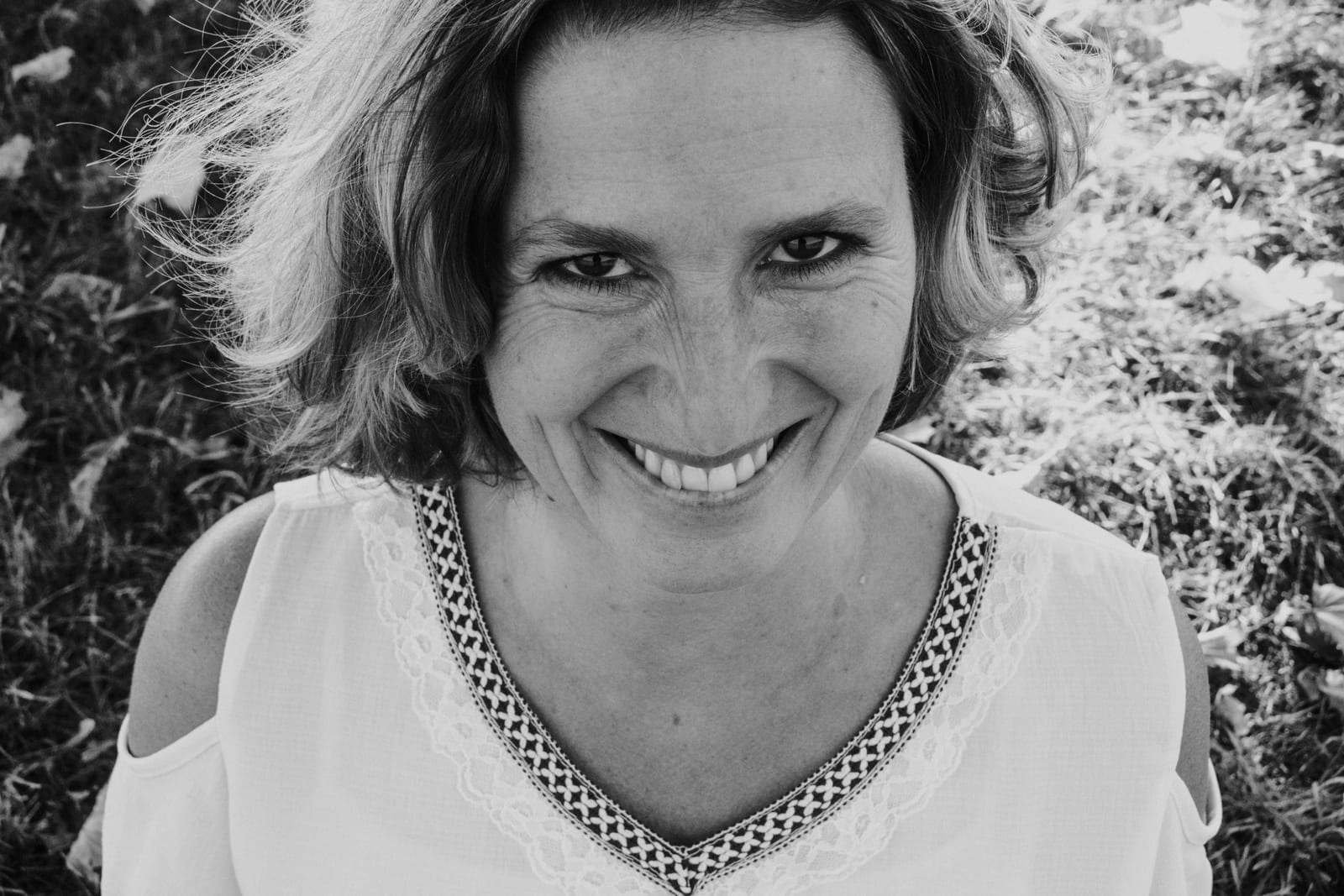 Claudia Reisecker im schwarzweißen Porträt, herzlich lächelnd